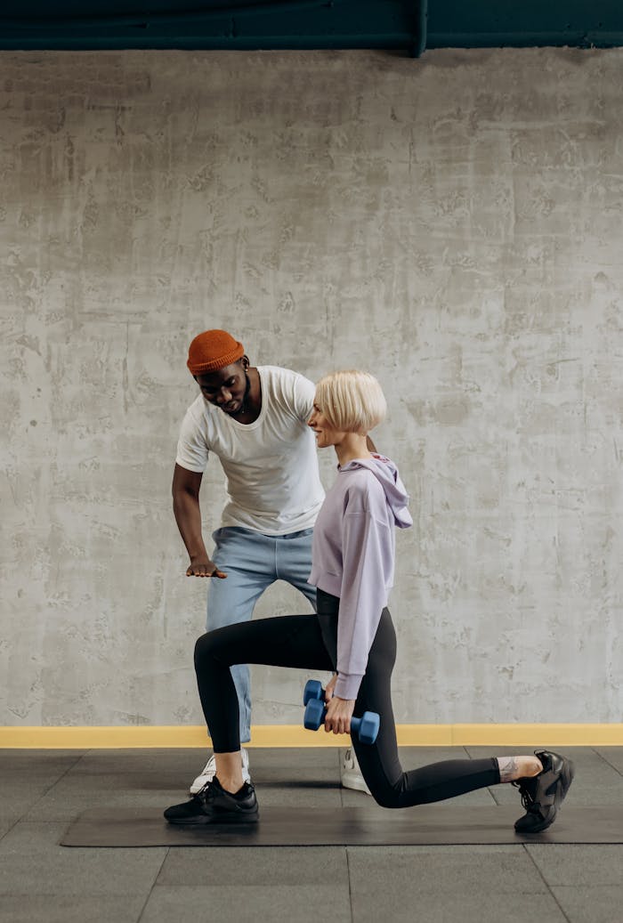 digital A personal trainer guides a woman doing lunges with dumbbells in a gym setting. Fitness and lifestyle concept.